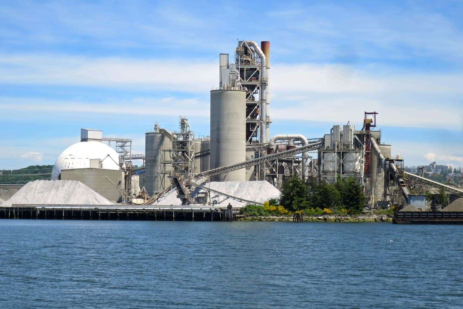 Cement plant with silos and conveyors beside a river